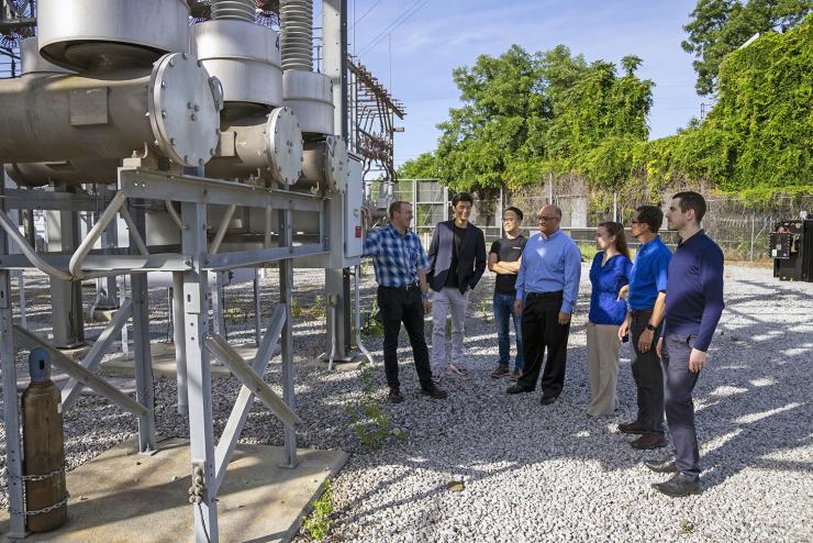 TESLA team examining a high-voltage circuit breaker The team examining a high-voltage circuit breaker at an electrical substation. The greenhouse gas, sulfur hexafluoride (SF6), is