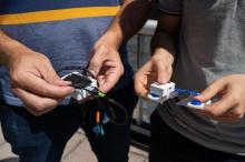 Close-up view of Omer Inan and Samer Mabrouk holding prototypes of their new sensor