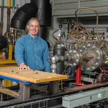combustors-thumb.jpg Benjamin Emerson stands with the high pressure liquid sprays combustor rig that his team uses to test novel combustor concepts.