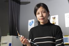 tbi-feature-hg.jpg Female researcher in Hong Yeo's lab holding a nanosensor