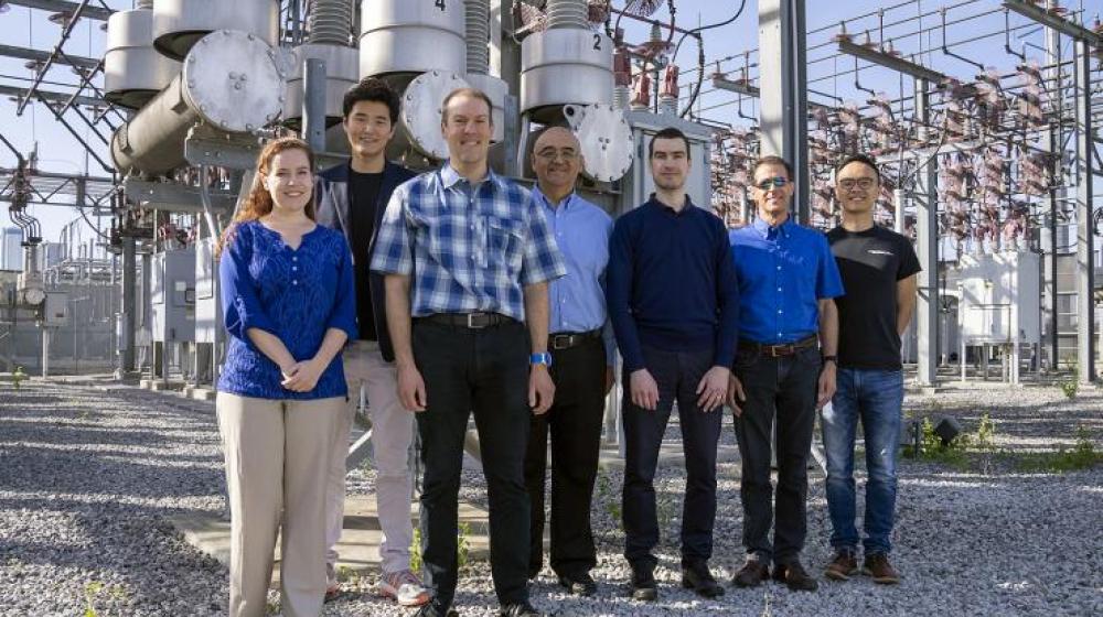 The TESLA (Tough and Ecological Supercritical Line Breaker for AC) team in front of high-voltage circuit breakers.